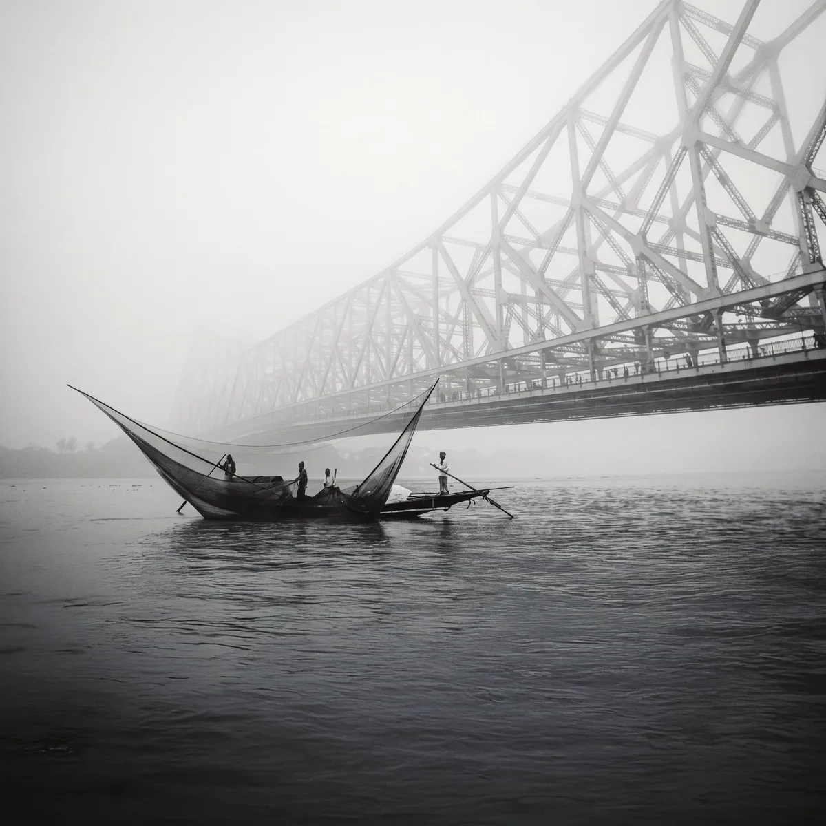 Howrah Bridge in morning mist with a country boat on the Hooghly